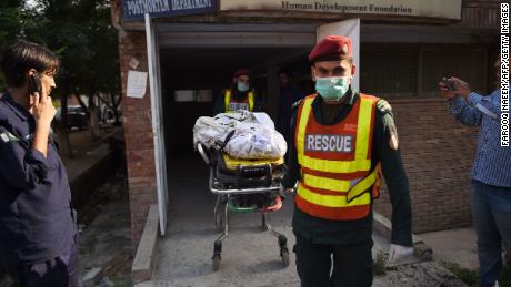 The body of a victim, killed after a Pakistani Army Aviation Corps aircraft crashed into residential buildings, is wheeled on a stretcher at hospital in Rawalpindi on July 30.