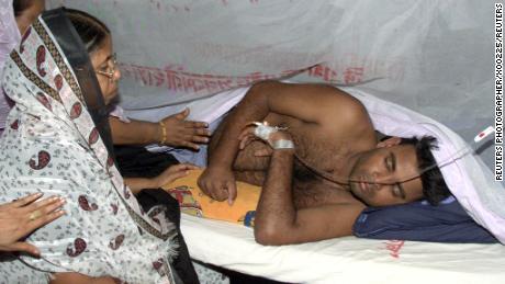 Relatives visit a victim of dengue fever at a hospital in Dhaka on
August 20, 2002. REUTERS/Rafiqur Rahman

