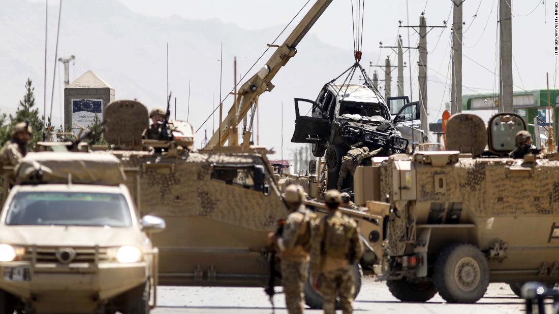 International forces belonging to NATO's Resolute Support mission remove a damage vehicle with a crane at the site of a car bomb attack in Kabul on May 31, 2019. 