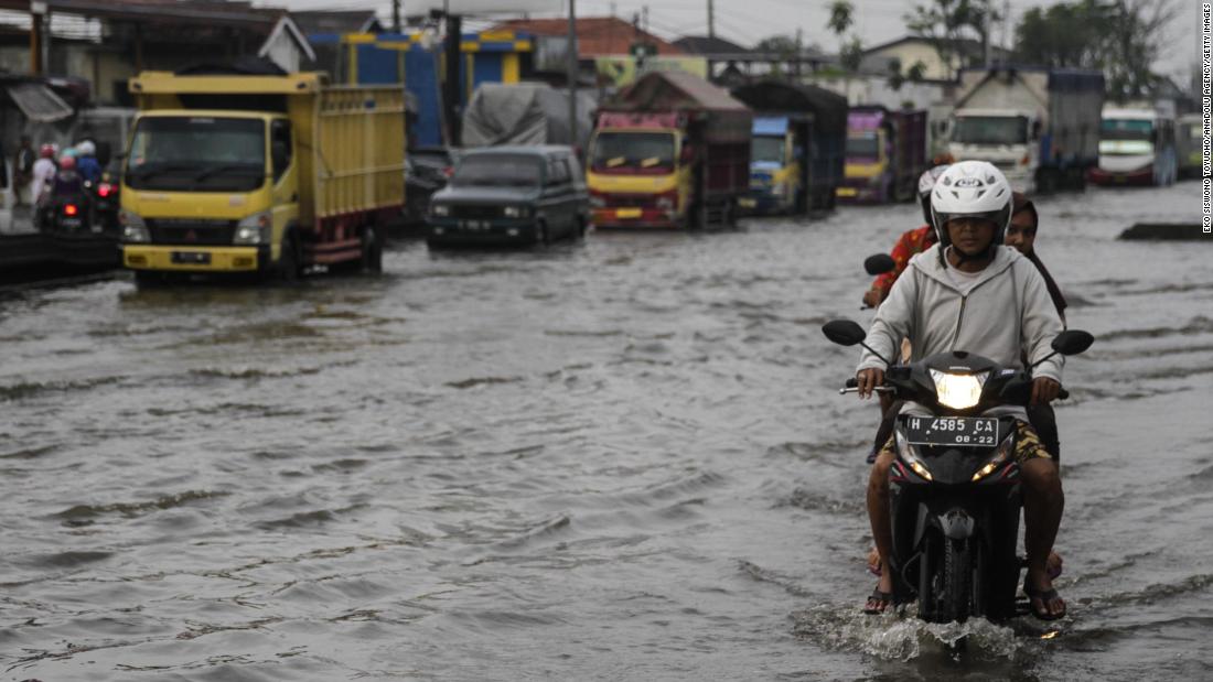 Vehicles in a flood caused by rising sea levels on a highway in Central Java, Indonesia on February 2.