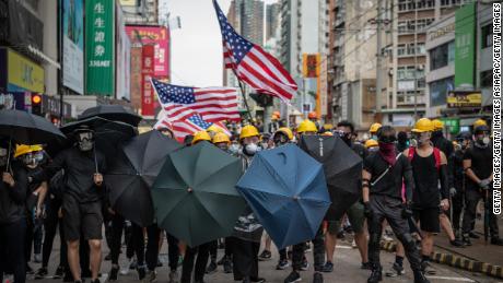 Protesters hold up umbrellas and American flags in the face of advancing riot police in the district of Yuen Long on July 27.