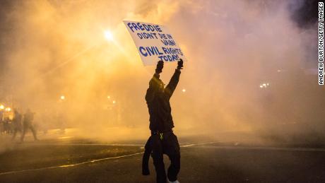 A protester walks through tear gas on April 28, 2015, as police enforce a curfew after the funeral of Freddie Gray in Baltimore.