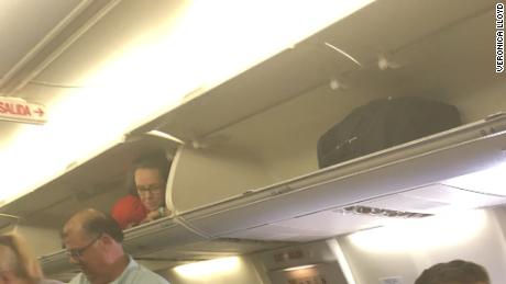 Flight Attendant Greets Passengers From Overhead Bin