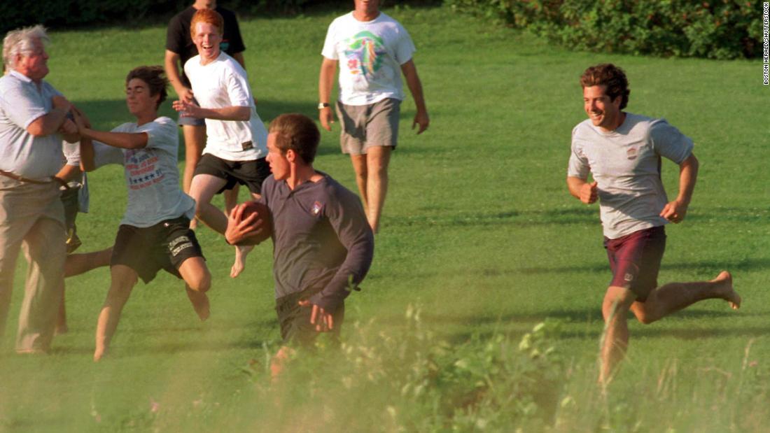 Ted Kennedy, left, and John Jr., right, join other family members for a football game in 1997.