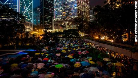 People from the finance community hold up umbrellas and shine lights during a protest against a controversial extradition bill in Hong Kong on August 1.