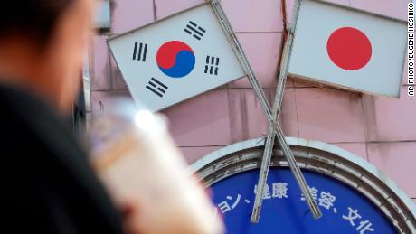 A woman walks past an advertisement featuring Japanese and South Korean flags at a shop in Shin Okubo area in Tokyo Friday, Aug. 2, 2019. Japan has approved the removal of South Korea from a &quot;whitelist&quot; of countries with preferential trade status, escalating tensions between the neighbors. The decision will fuel antagonism between the two neighbors already at a boiling point over the export controls and the issue of compensation for wartime Korean laborers. (AP Photo/Eugene Hoshiko)