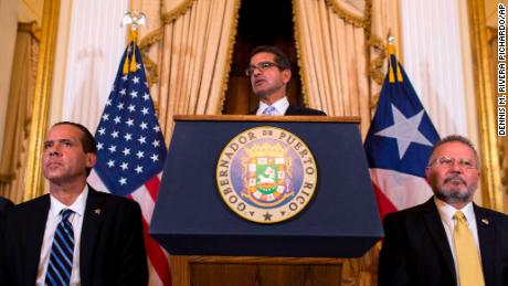 Pedro Pierluisi, sworn in as Puerto Rico&#39;s governor, speaks during a press conference, in San Juan, Puerto Rico, Friday, Aug. 2, 2019. Departing Puerto Rico Gov. Ricardo Rossello resigned as promised on Friday and swore in Pierluisi, a veteran politician as his replacement, a move certain to throw the U.S. territory into a period of political chaos that will be fought out in court. Pierluisi is flanked by lawmakers Jorge Navarro, left and Jose Aponte.  (AP Photo/Dennis M. Rivera Pichardo)