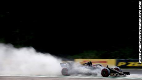 Kevin Magnussen drives through cement dust laid down by marshals.