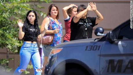 Shoppers exit with their hands up after a shooting in El Paso, Texas, on Saturday.