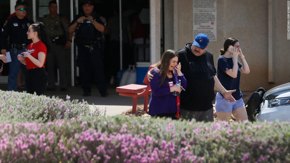 People gather at MacArthur Elementary School in El Paso, looking for family and friends. The school was being used as a reunification center.