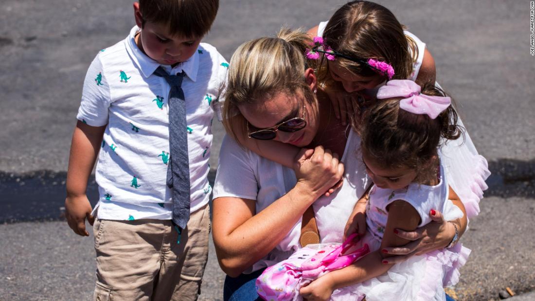 Cristina Zapata and her children pay their respects to the victims of the El Paso shooting.