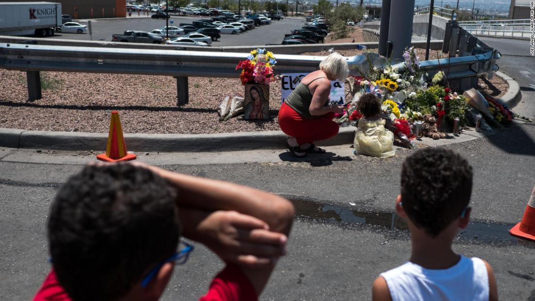 People pay their respects to the victims of the El Paso shooting at a makeshift memorial across from the Walmart near the Cielo Vista Mall.