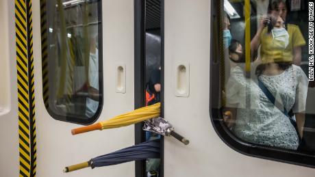 A group of protesters prevent the doors of a commuter train from closing on August 5.