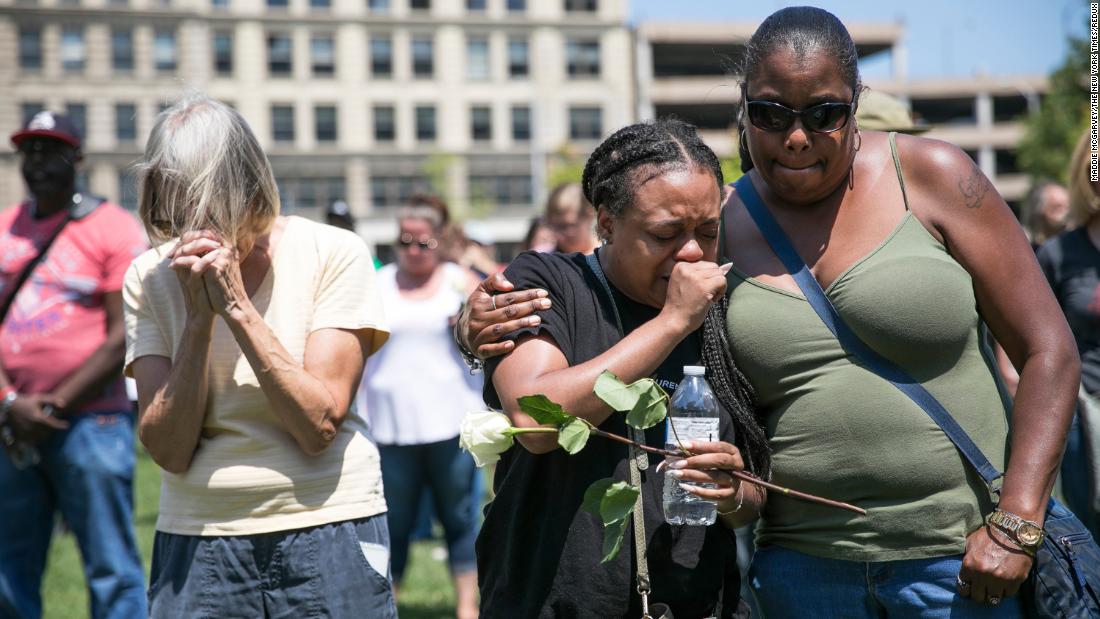 Mourners gather Sunday at a vigil in Dayton.