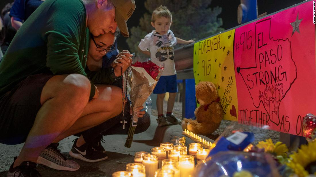 Mourners pray at a makeshift memorial for the victims of the El Paso shooting.