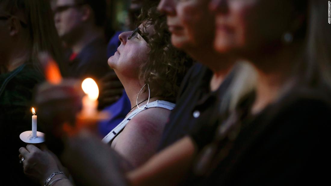 Mourners pause for a prayer in Dayton.