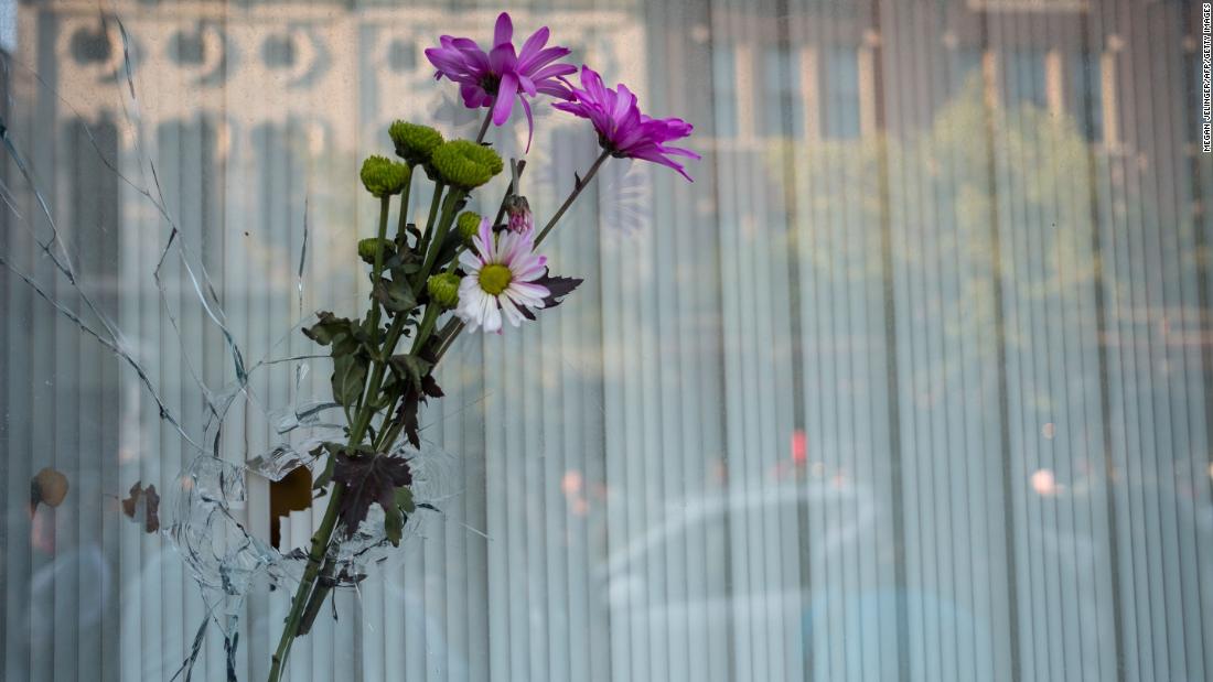 Flowers are placed in a bullet hole a few buildings away from where the shooting took place in Dayton.