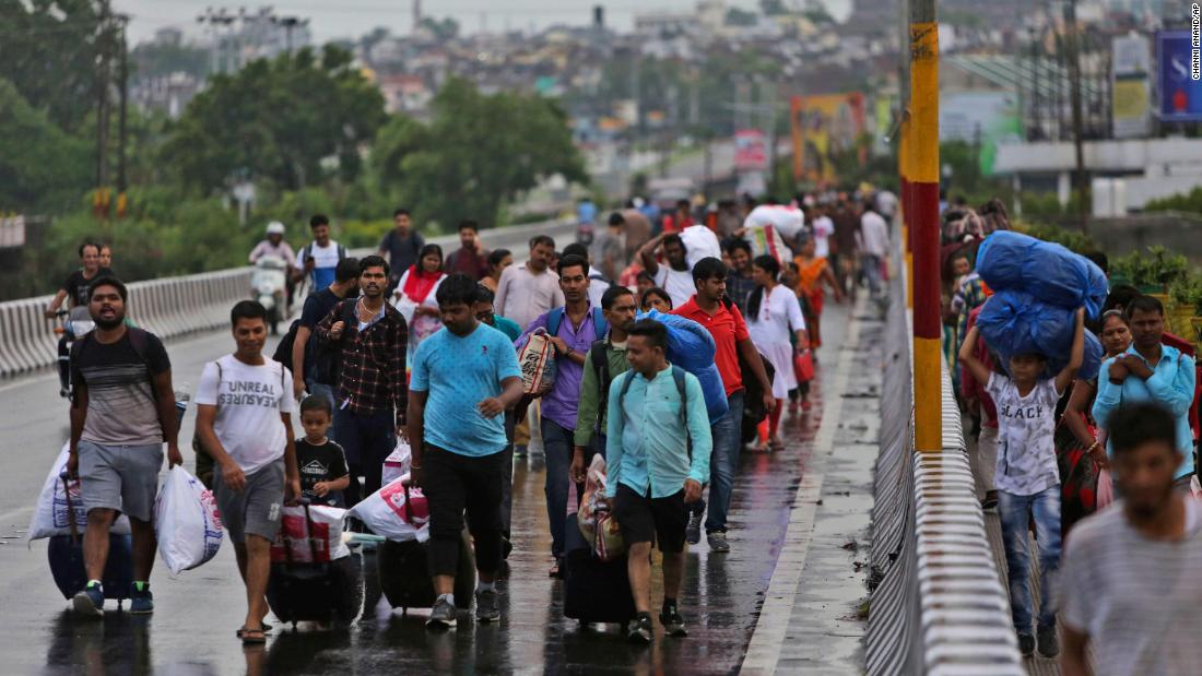 Stranded Indian tourists walk to a railway station during restrictions in Jammu on August 5, 2019. 