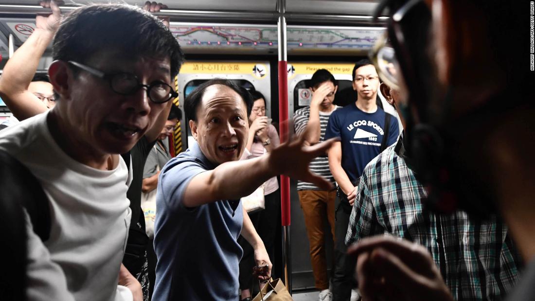 A train passenger gestures toward a protester, right, who was preventing the doors of a train from closing on August 5. The protester was trying to disrupt Hong Kong&#39;s morning rush-hour commute.