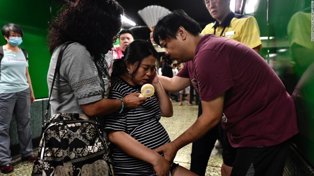 A man comforts his pregnant wife near a train platform after protesters blocked the train doors on August 5.