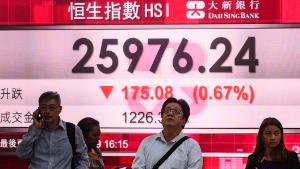 Pedestrians stand in front of a stocks display board showing the Hang Seng index at 25976.24, down 0.67 percent, in Hong Kong on August 6, 2019. - Hong Kong shares pared back early losses but still closed lower on August 6, tracking a global sell-off as fears over a US-China trade war rattled investors. (Photo by Philip FONG / AFP)        (Photo credit should read PHILIP FONG/AFP/Getty Images)