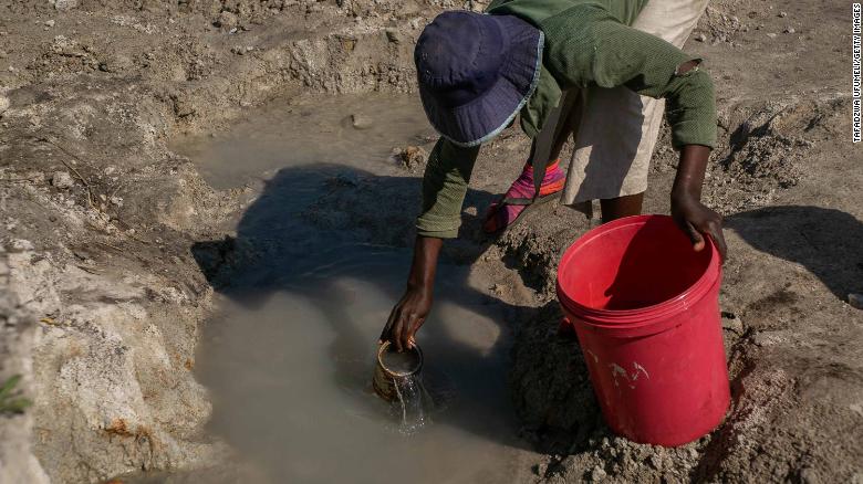 A woman fetches water from a spring in Harare.