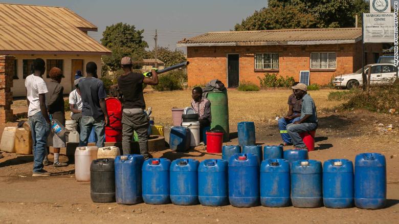 Residents in Harare queue for water.