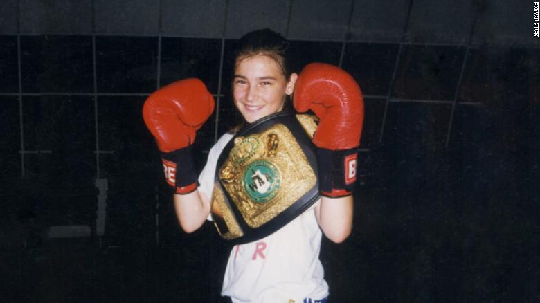 Katie Taylor with boxing gloves and a belt.