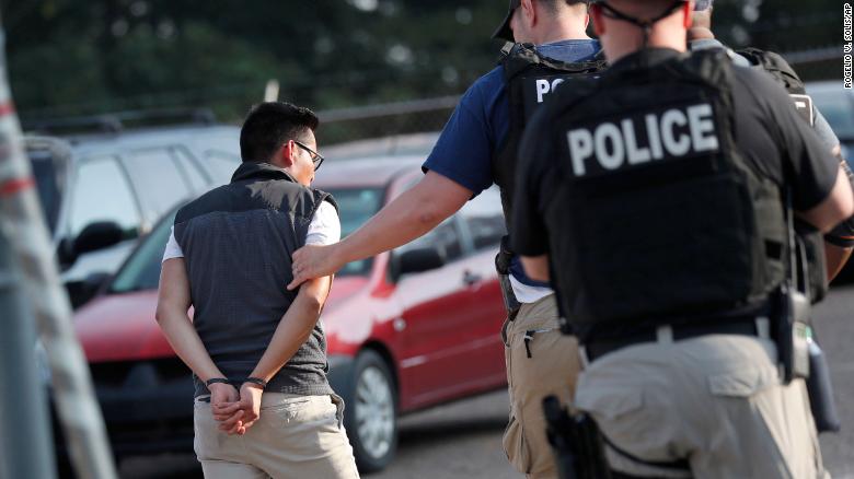 A man is taken into custody at a Koch Foods Inc. plant in Morton, Mississippi, on Wednesday. 