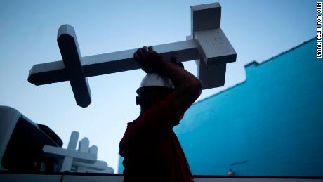 In Dayton, Ohio, Greg Zanis carries one of the more than 26,000 crosses he made.