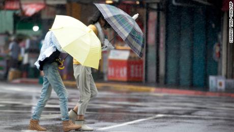 Two Taiwanese women face powerful gusts of wind generated by Typhoon Lekima in Taipei, Taiwan, on August 9, 2019. 