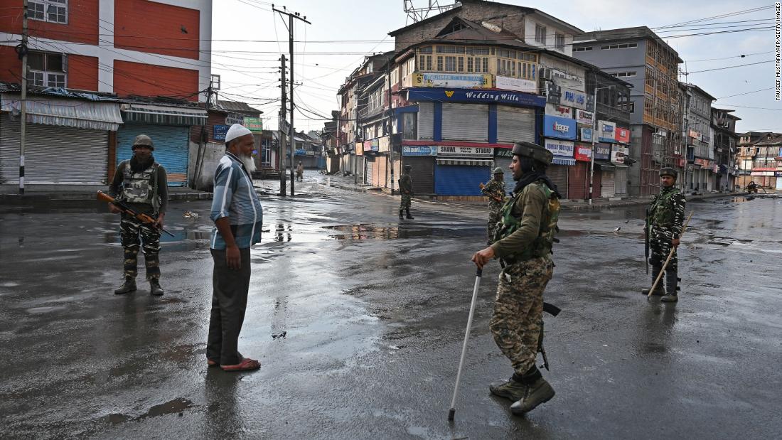 Indian security personnel question a man on a street during a curfew in Srinagar on August 8, 2019, as widespread restrictions on movement and a telecommunications blackout remained in place.