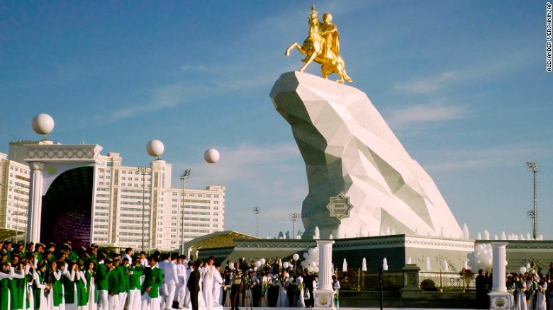 People gather for the unveiling ceremony of a 21-meter, gold-leaf statue of President Gurbanguly Berdymukhamedov atop a horse mounted on a towering pile of marble in Ashgabat, Turkmenistan, in 2015. 