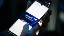 A guest holds her phone showing a picture taken during Huawei's press conference unveiling its new HarmonyOS operating system in Dongguan, Guangdong province on August 9, 2019. - Chinese telecom giant Huawei unveiled its own operating system on August 9, as it faces the threat of losing access to Android systems amid escalating US-China trade tensions. (Photo by FRED DUFOUR / AFP)        (Photo credit should read FRED DUFOUR/AFP/Getty Images)