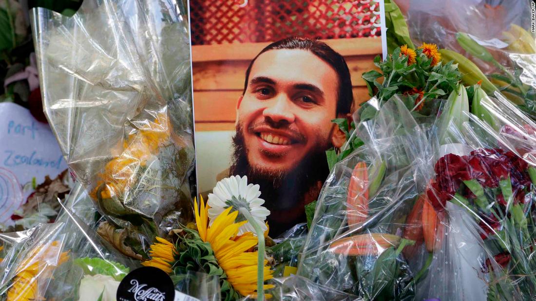 A photo tribute for Christchurch mosque shooting victim Tariq Omar lies amid mounds of flowers across the road from the Al Noor mosque in Christchurch, New Zealand Tuesday, March 19, 2019. 