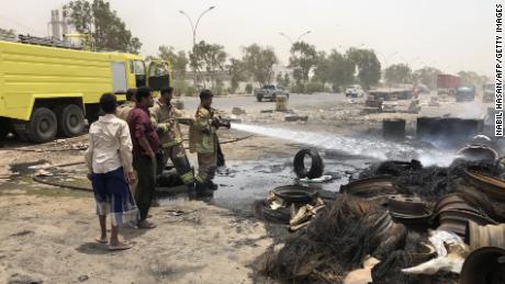 Firefighters extinguish a fire following clashes between pro-government forces and separatists in Aden on August 11, 2019.