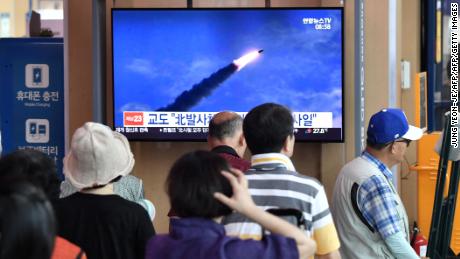 People watch a television news screen showing file footage of a North Korean missile launch this month.