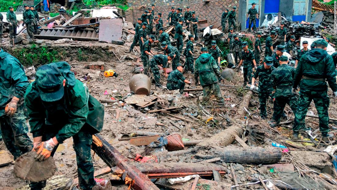 Rescuers look for survivors in the rubble of damaged buildings after a landslide in Yongjia.