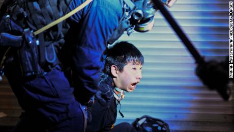 A pro-democracy protester is held by police outside Tsim Sha Tsui Police station on August 11, 2019.