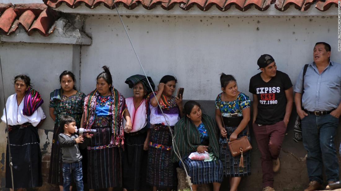 Guatemalan migrants deported from the US standing outside an Air Force base after arriving in Guatemala City.