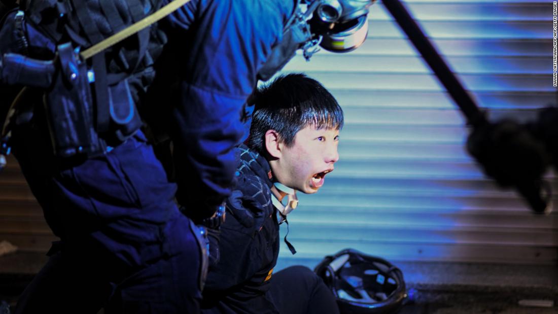 A pro-democracy protester is held by police outside the Tsim Sha Tsui police station on August 11.