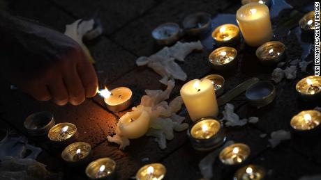  A man tends a makeshift candlelight vigil for Heather Heyer and those who were hurt in Charlottesville, Virginia, in August 2017.