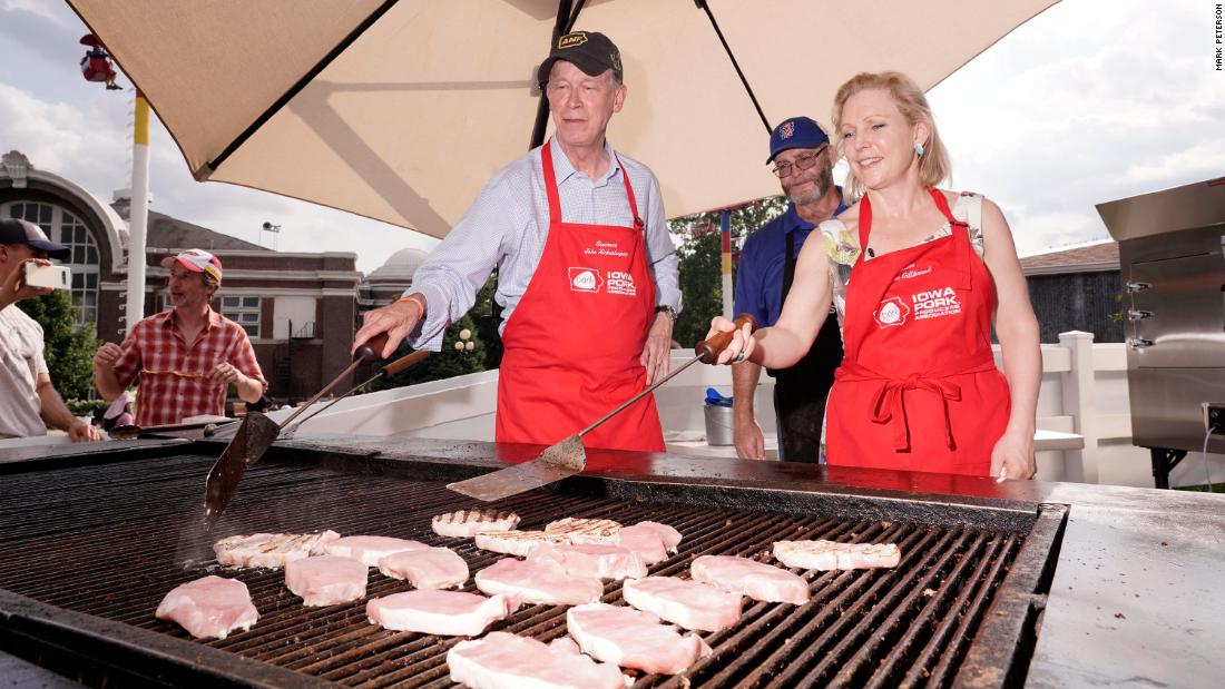 Gillibrand flips pork chops at the Iowa State Fair along with John Hickenlooper, another Democratic presidential candidate, in August 2019.