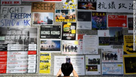 A woman takes photographs of messages by pro-democracy protesters against the controversial extradition bill at Hong Kong&#39;s international airport on August 11, 2019.