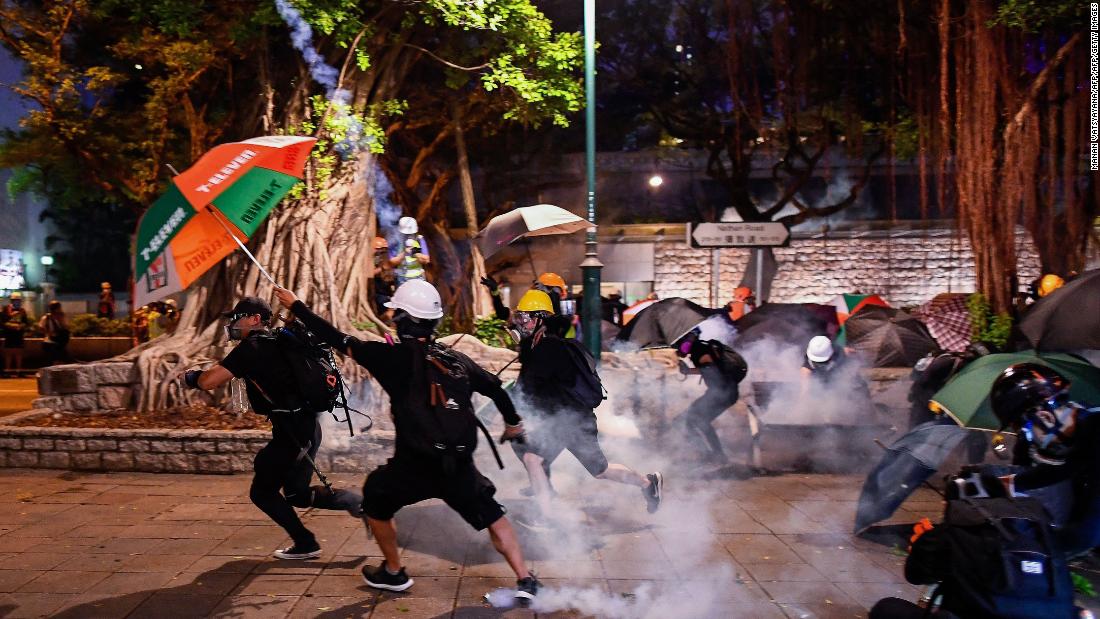 Pro-democracy protesters throw back tear gas cannisters in Tsim Sha Tsui district during a demonstration against the controversial extradition bill in Hong Kong on August 11, 2019.