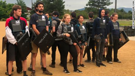 Participants pretend to be police during a protest scenario.