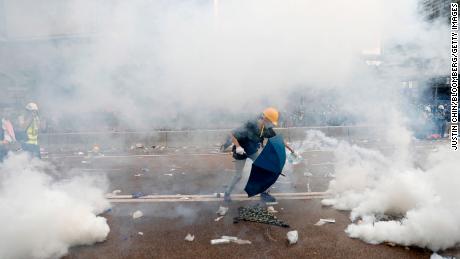 A protester douses a tear gas canister with water outside the Legislative Council during a protest against a proposed extradition law in Hong Kong, China. 