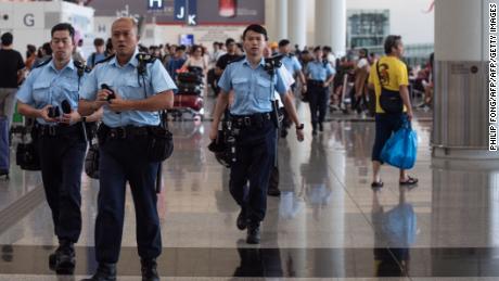 Police officers patrol in the departures hall of Hong Kong&#39;s International airport on August 14, 2019. 