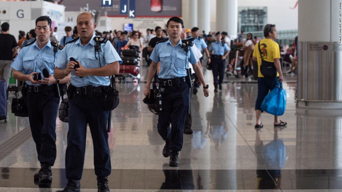 Police officers patrol in the departures hall of Hong Kong's International airport on August 14, 2019. 