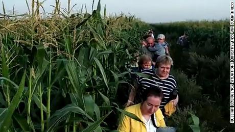 Passengers make their way through a cornfield near Zhukovsky International Airport after their flight made an emergency landing on Thursday.